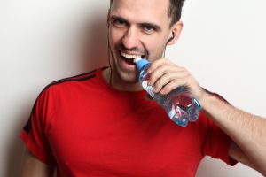 Man Opening Bottled Water with Teeth